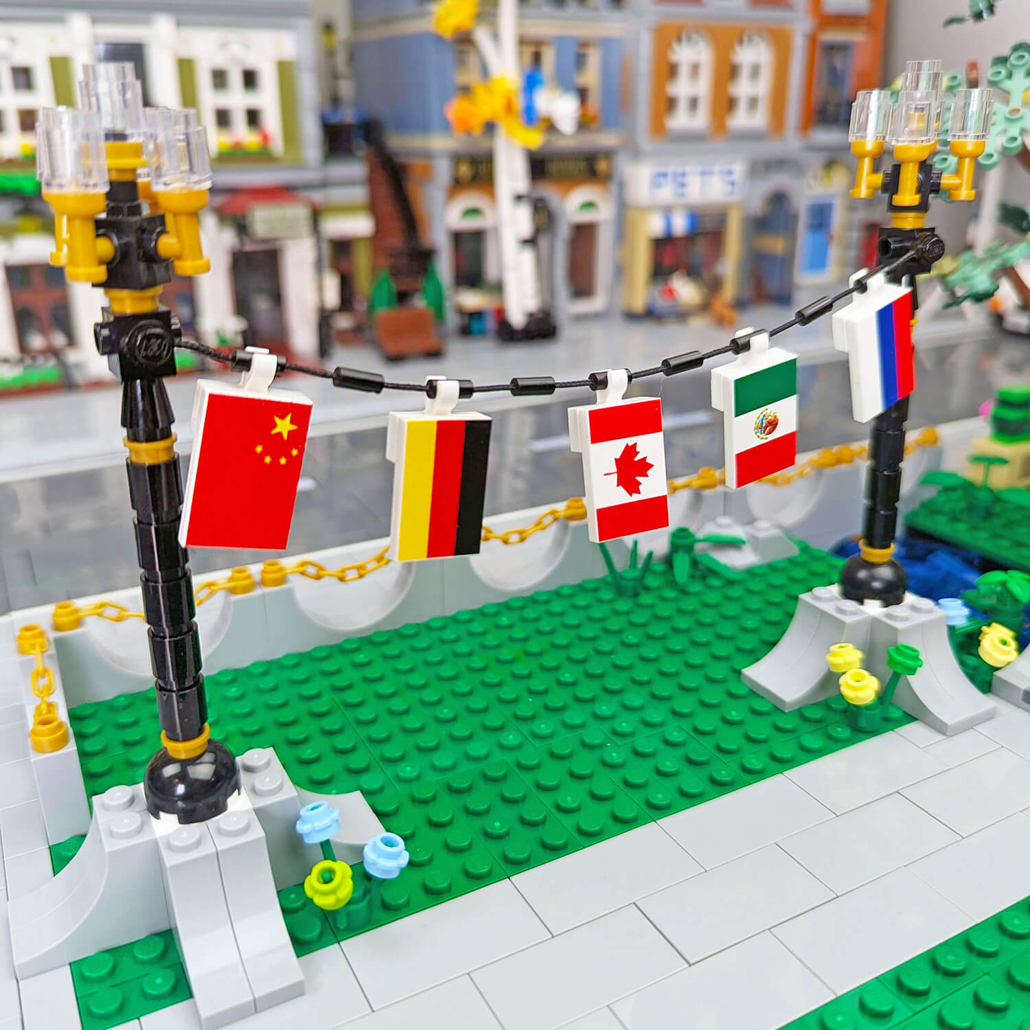 LEGO model of a street scene with a banner displaying various country flags, printed on lego