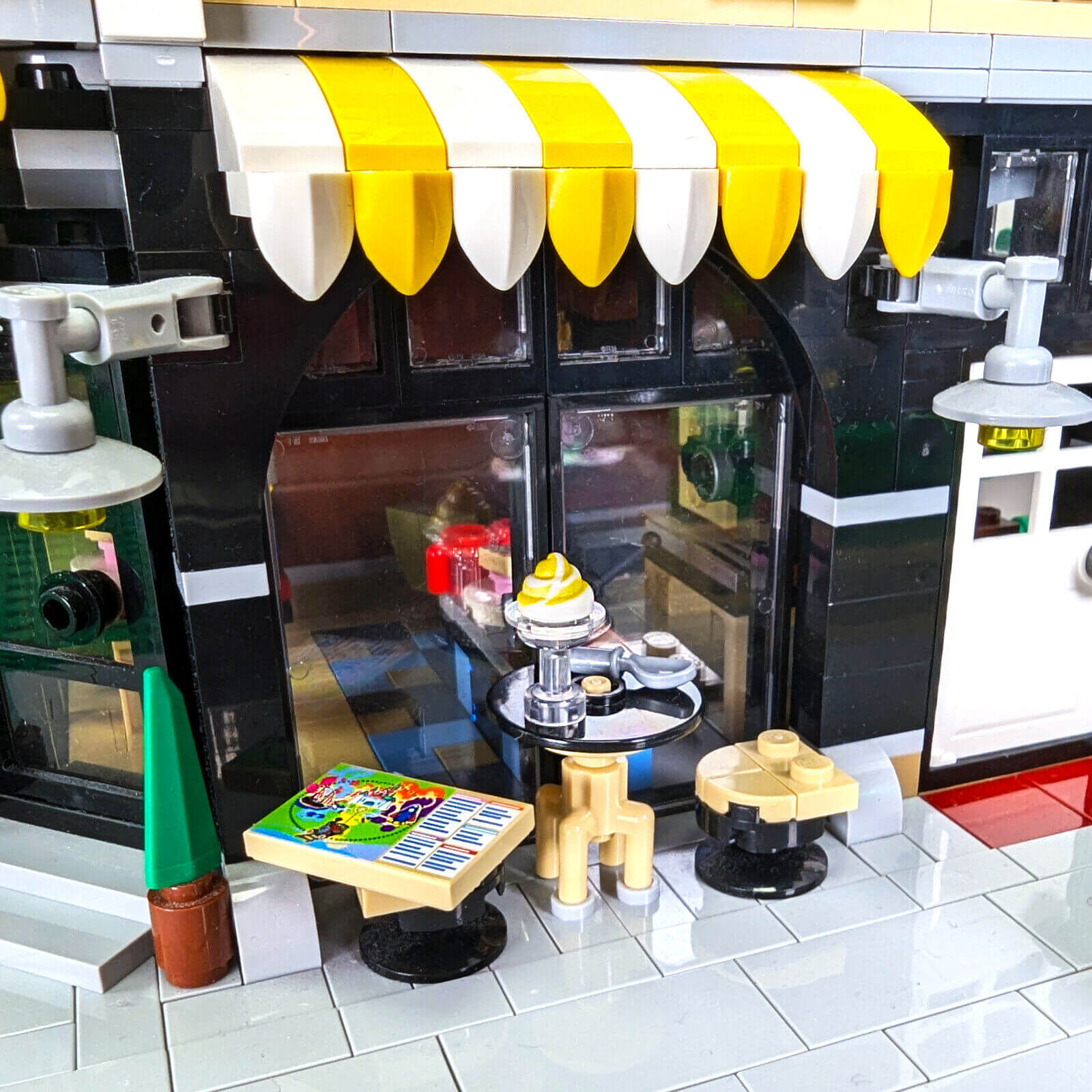 Toy kitchen set with a yellow and white canopy, sink, and various accessories on a tiled floor.