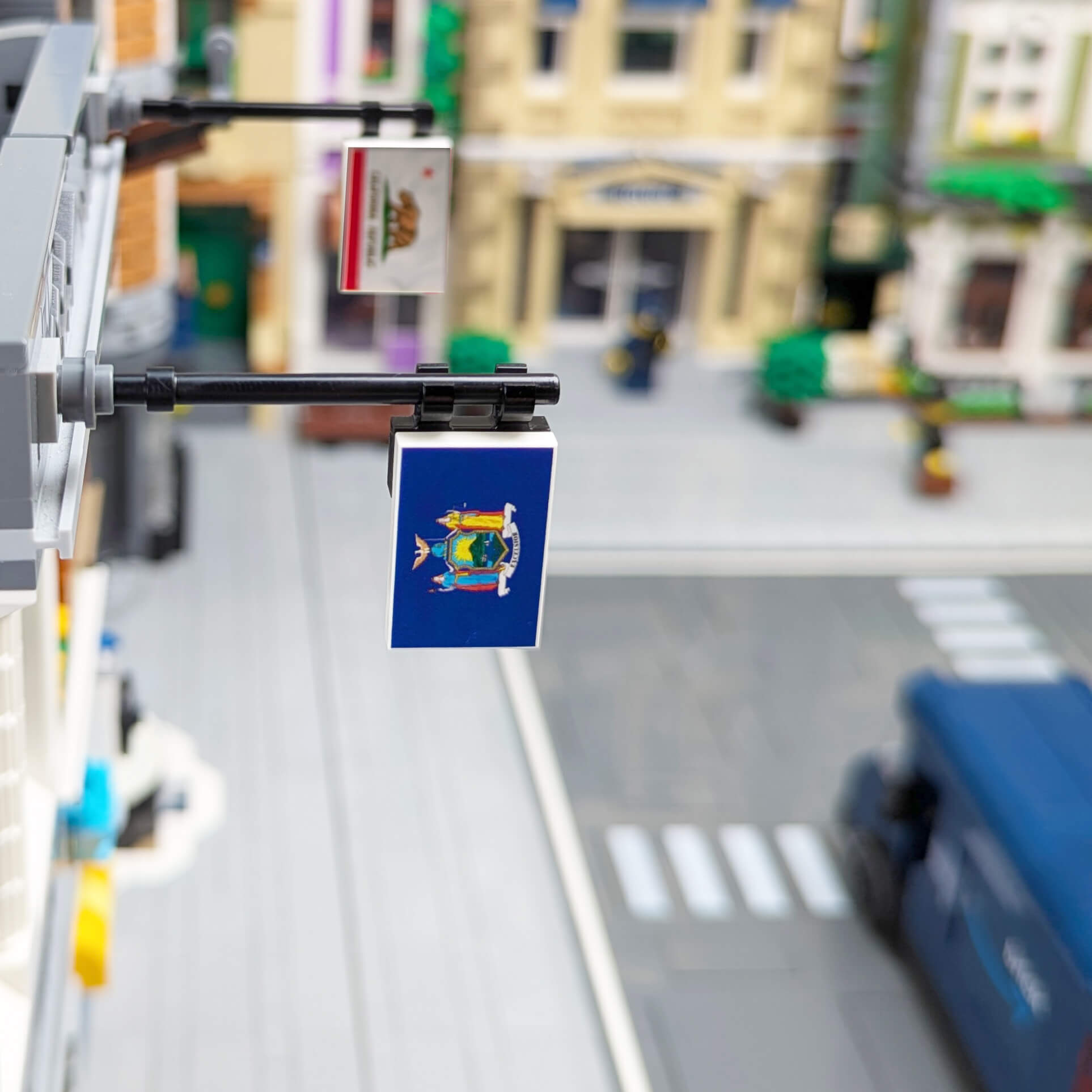 Model of a street scene with a New York state flag featuring a coat of arms, blurred background