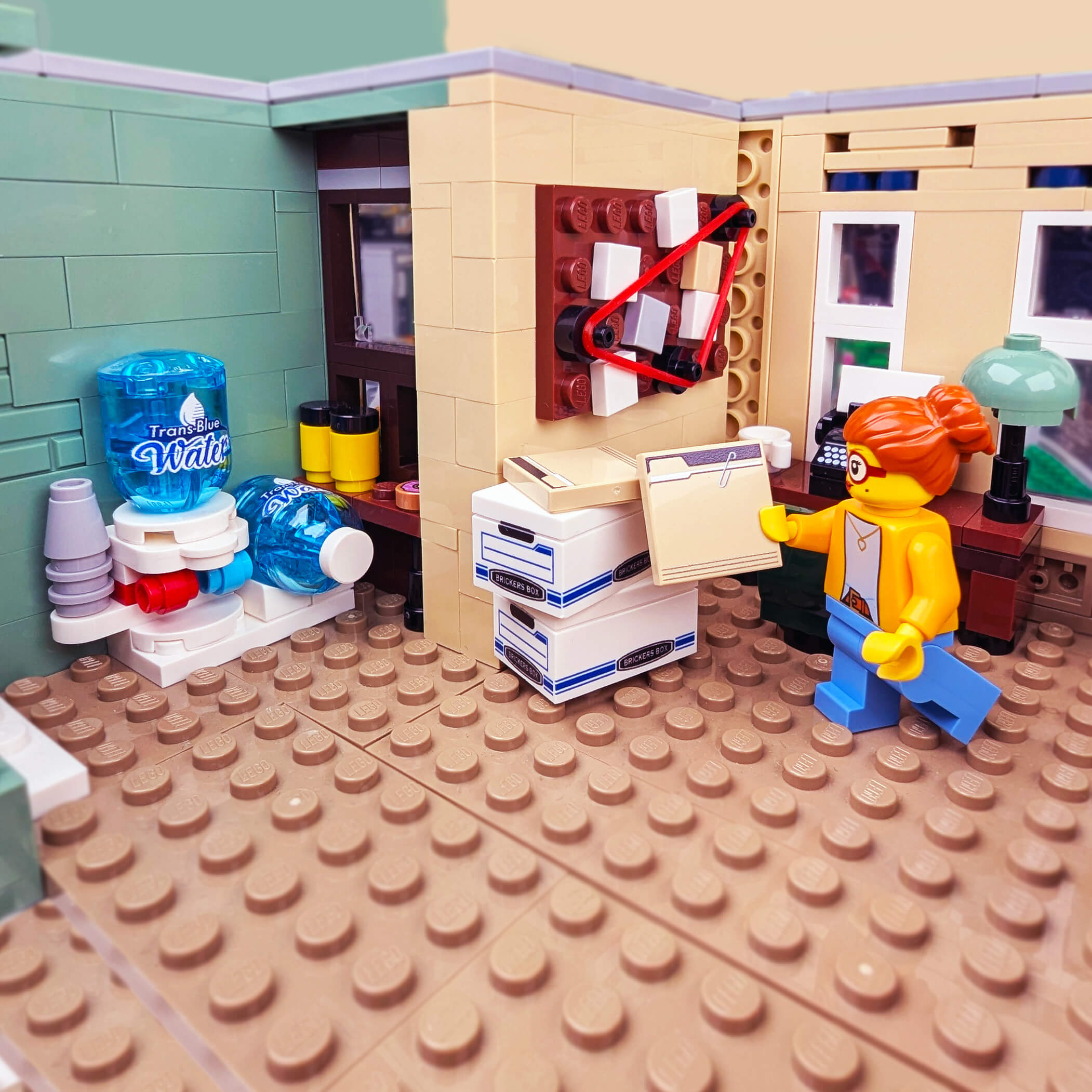 LEGO model of a person at a desk with office supplies and a water cooler.