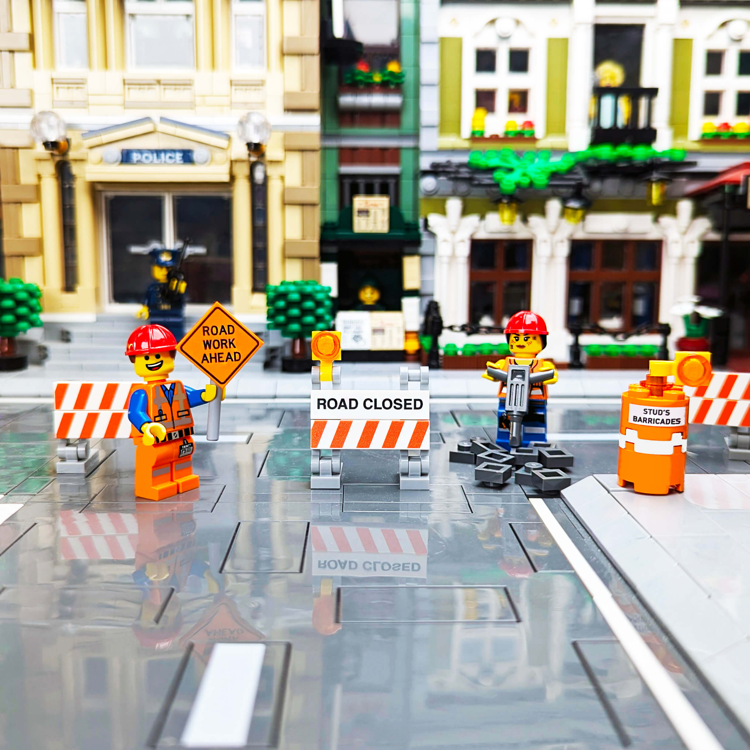 Lego construction workers with road closed signs in a city background