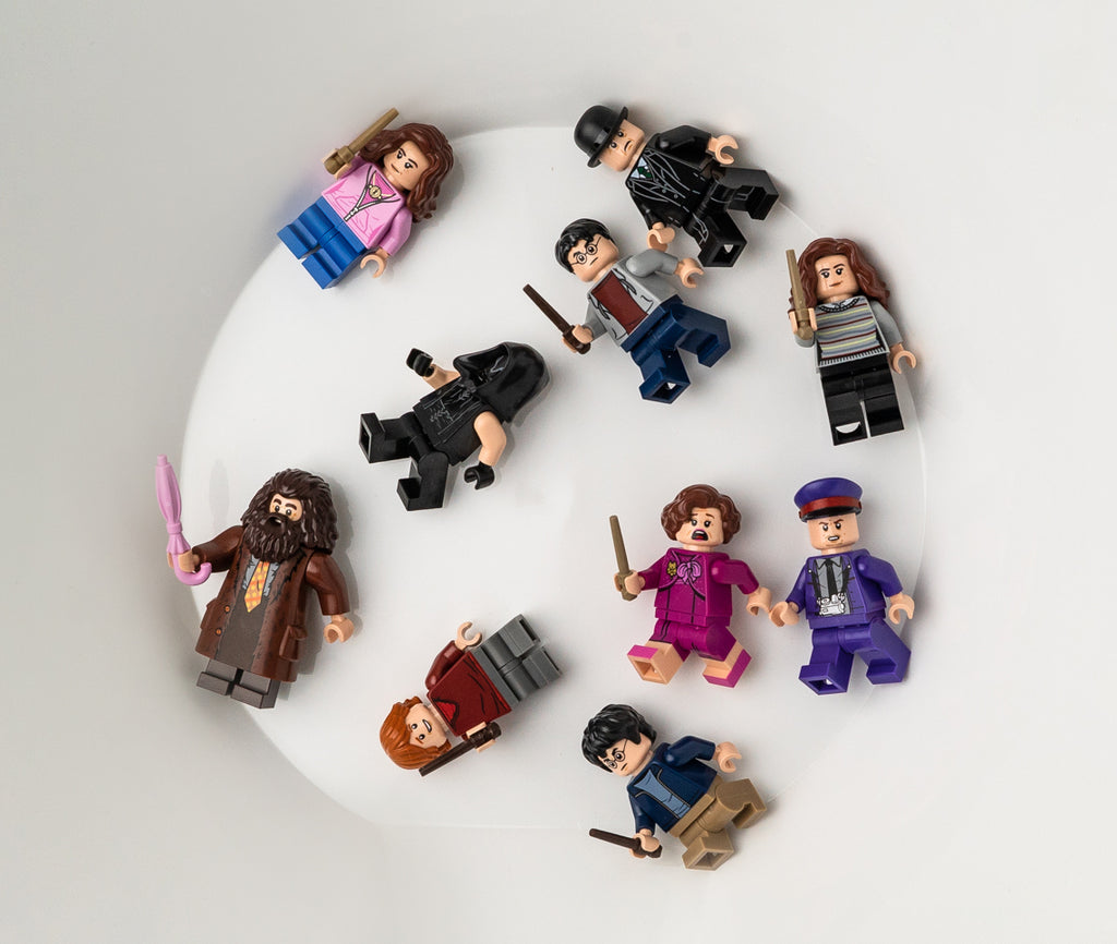 different minifigures in a round bin, mostly from harry potter