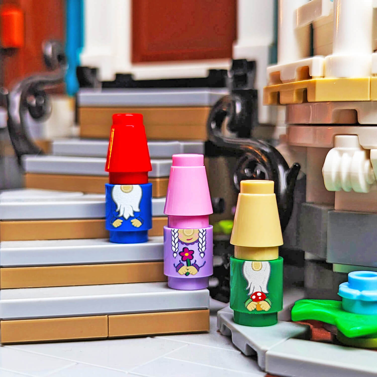 Colorful garden gnomes made from lego placed on a staircase with a blurred background