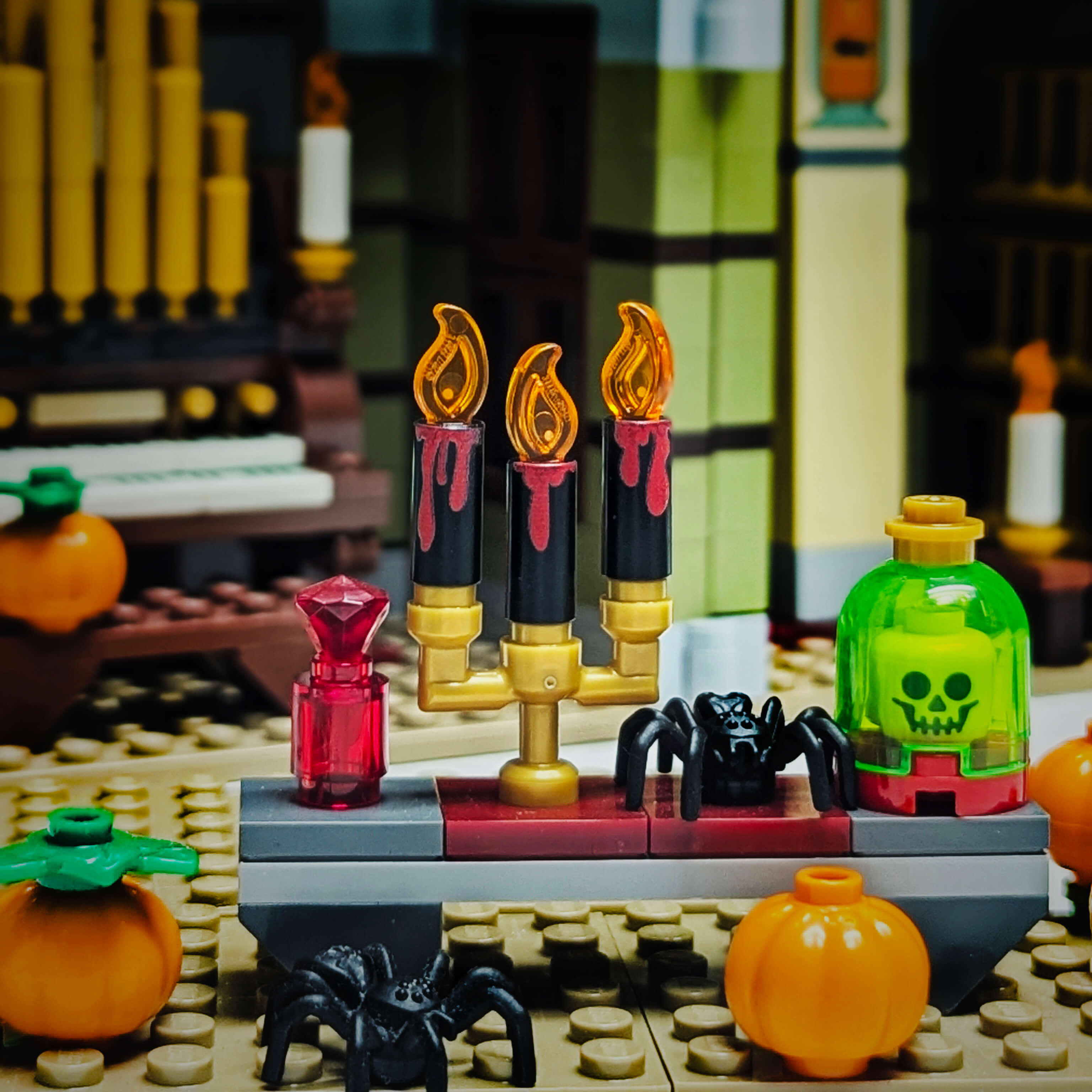 LEGO Halloween setup with candles, pumpkins, and a spider on a dark background