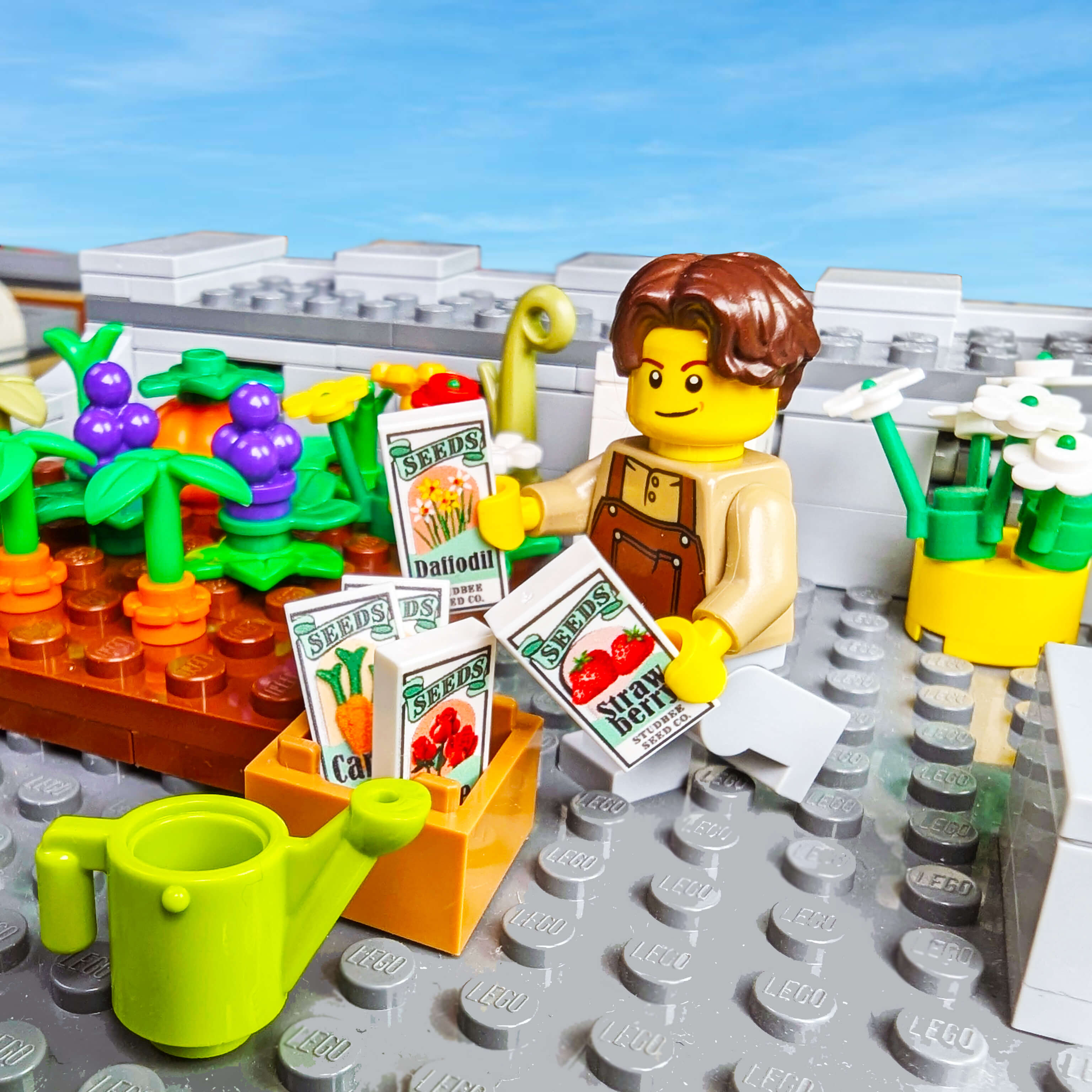 LEGO figure of a gardener with plants and seed packets on a gray baseplate.