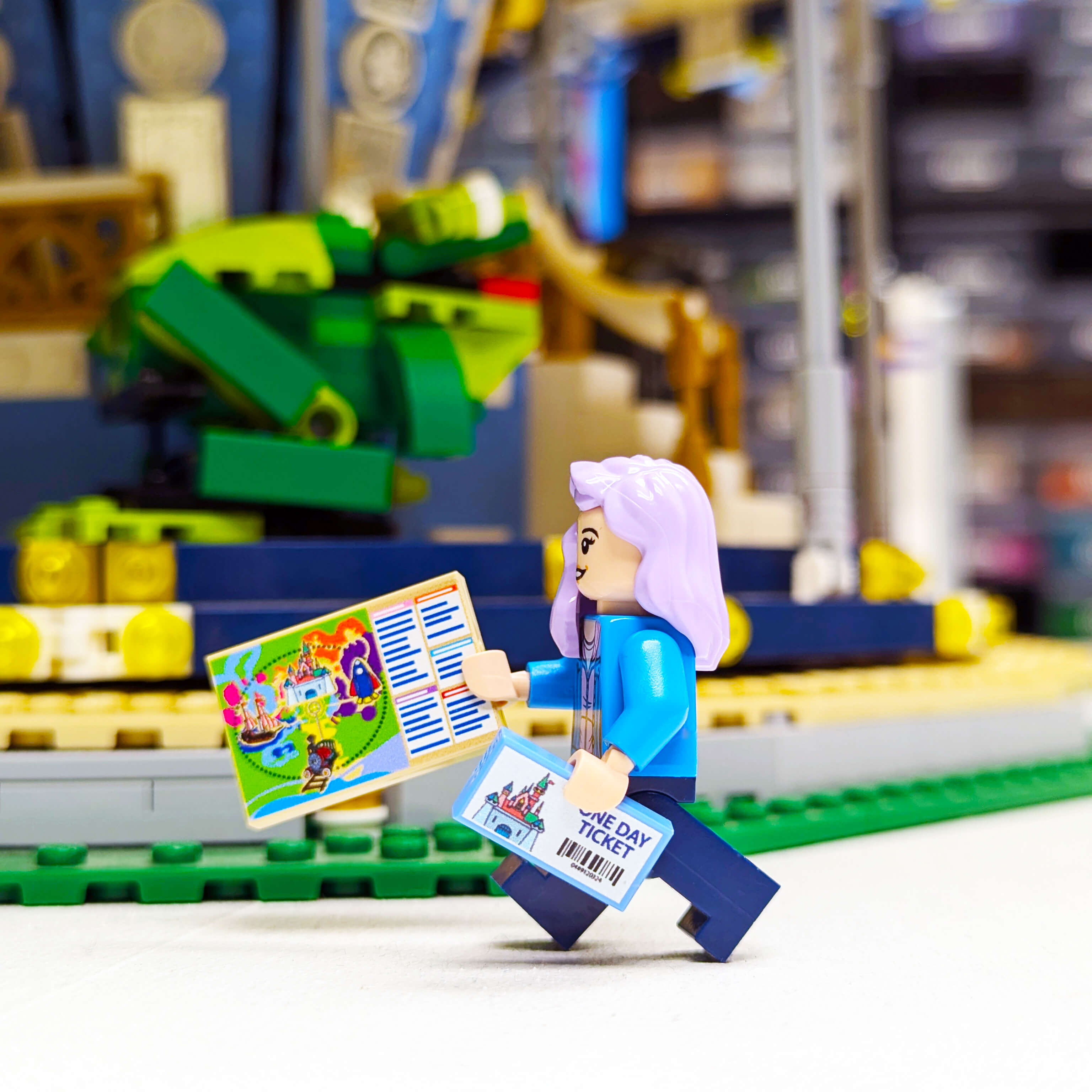Minifig holding a ticket and map with a blurred LEGO set in the background