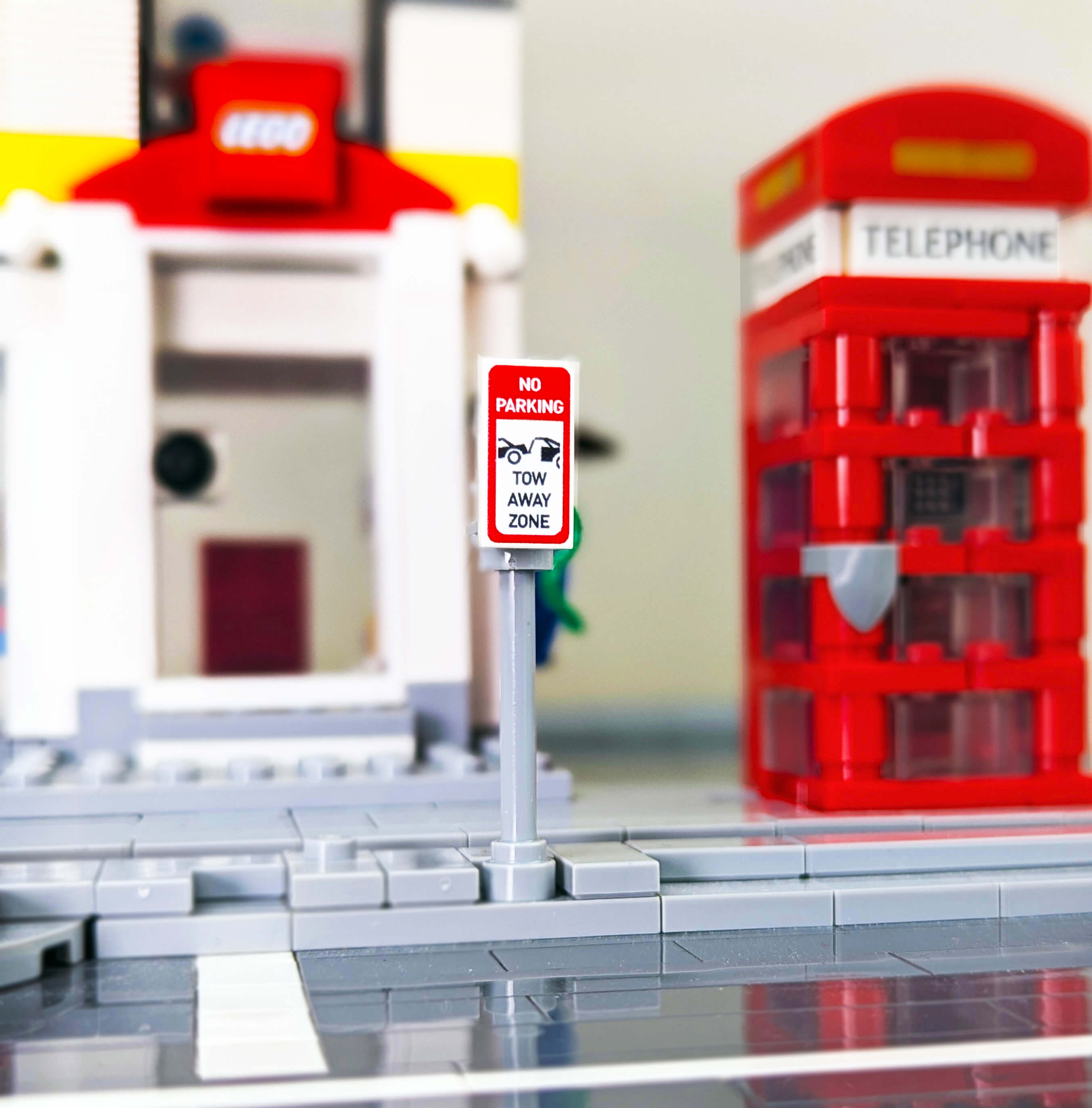 LEGO telephone booth and no parking sign in a brick city with a blurred background