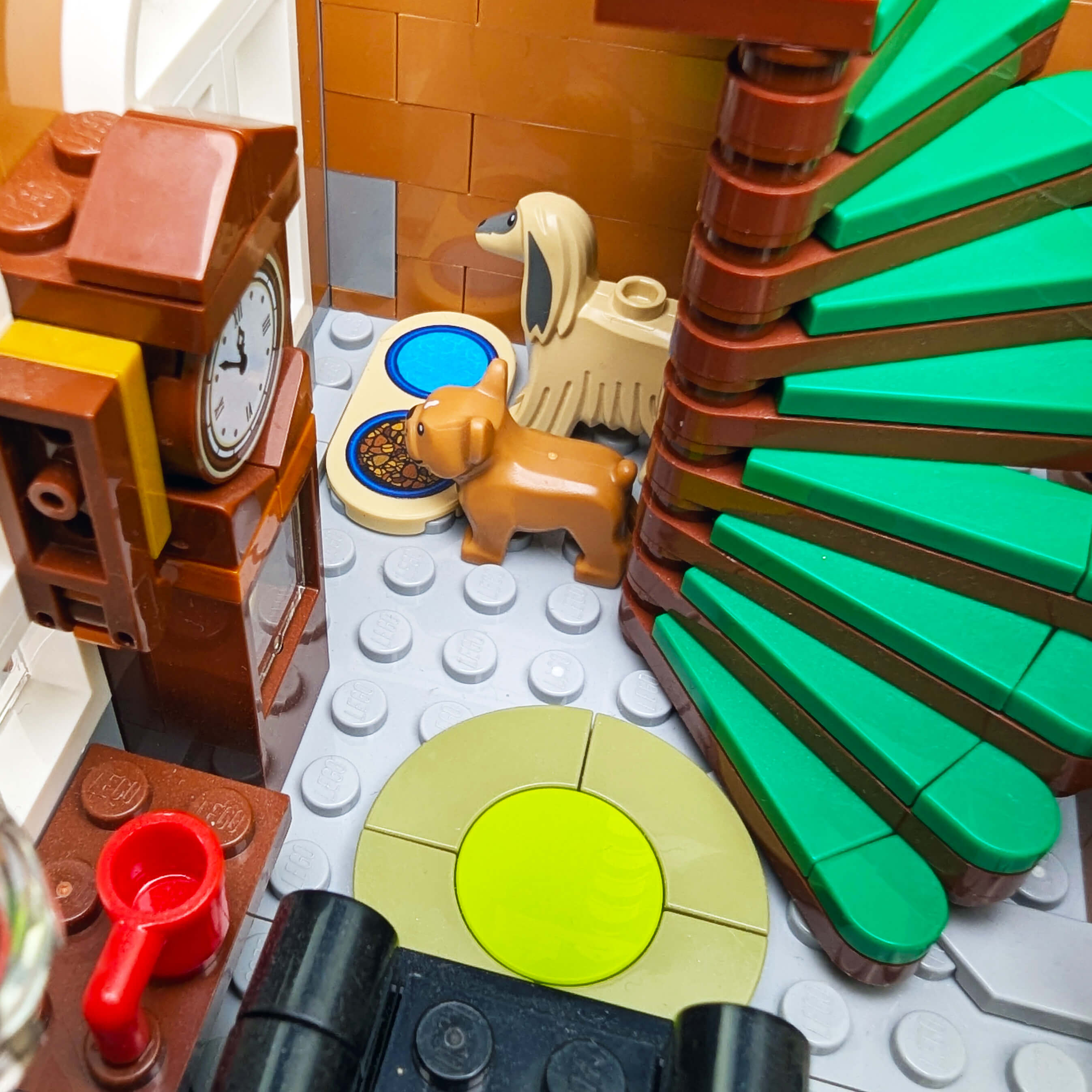 Close-up of a LEGO house with various pieces including a clock, dog, and green leafy plant.