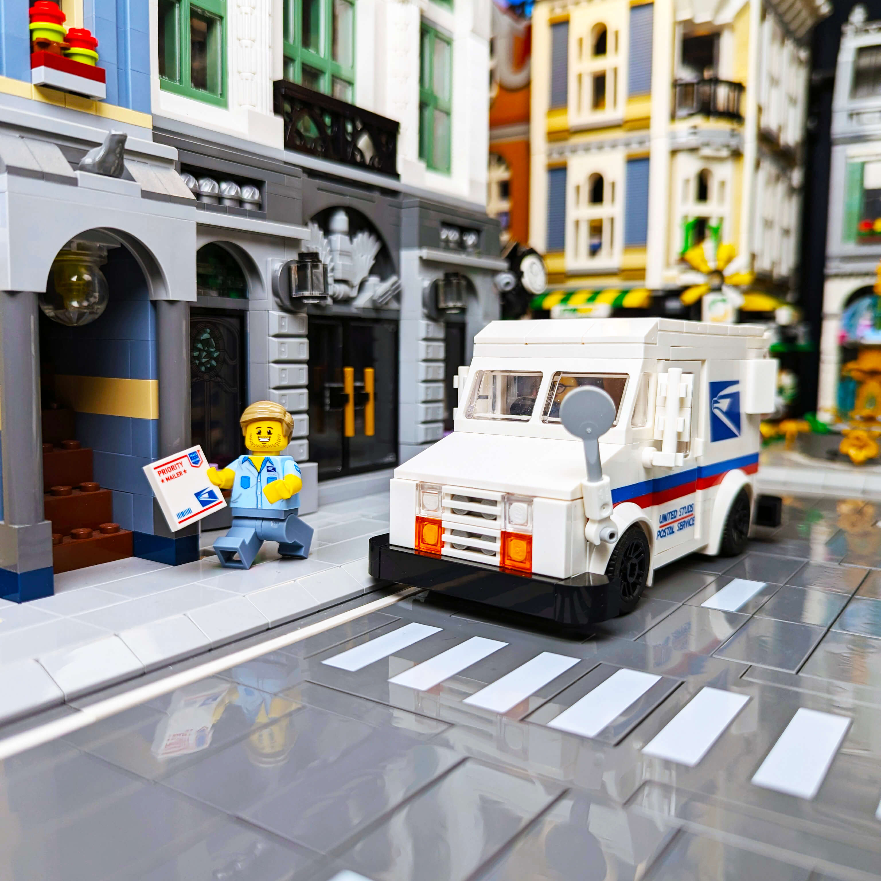 Custom Postal Worker minifigure delivering a priority mailer, in front of a brick built postal truck