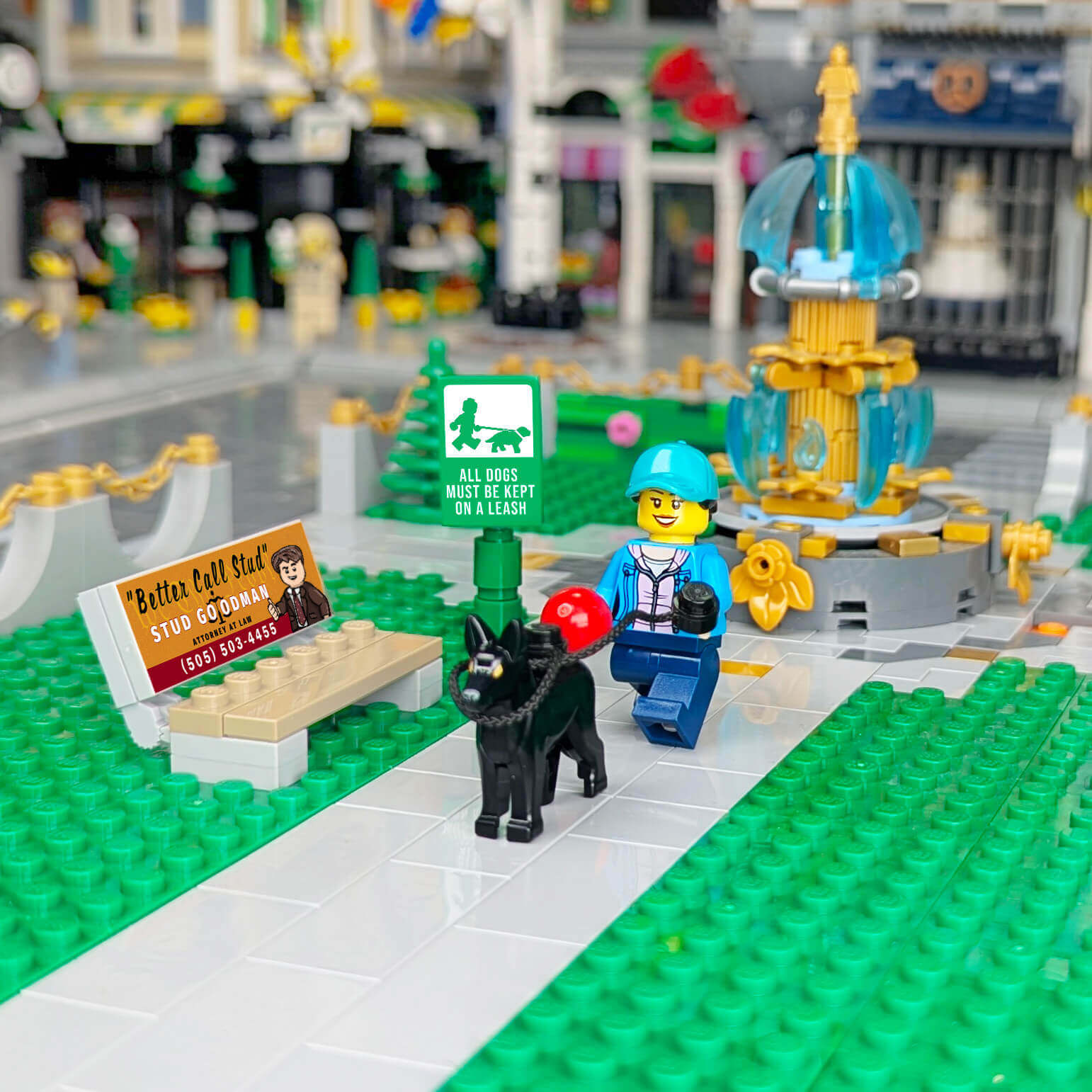 LEGO scene with a dog, person, advertising bench in a brick built part setting and sign in an urban setting