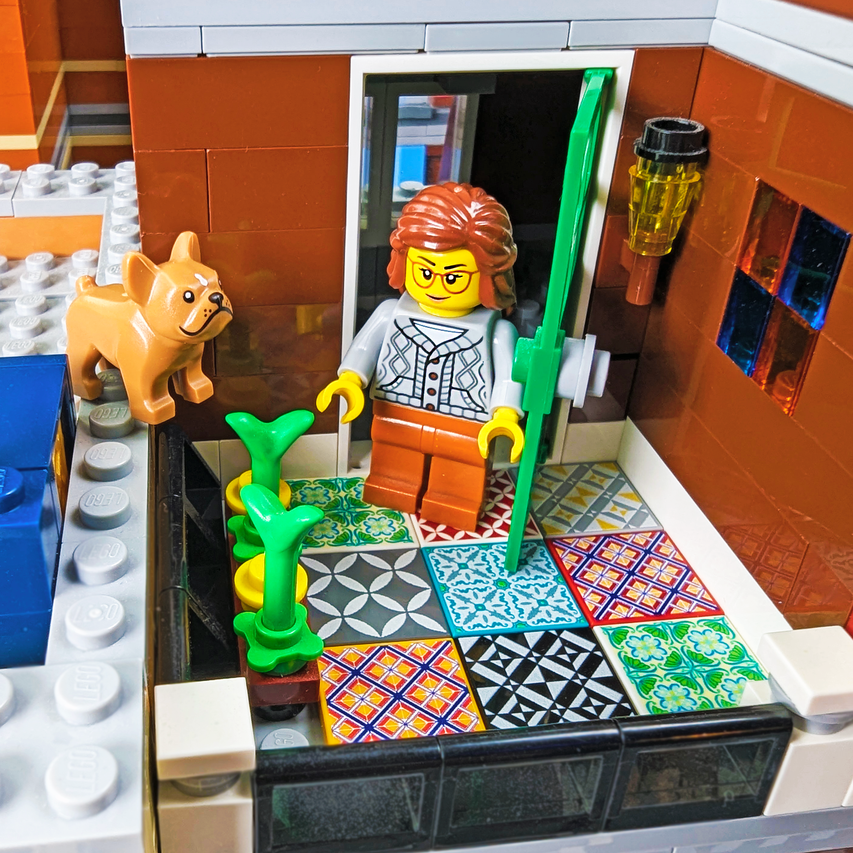 LEGO figure with a dog and decorative tiles in an outdoor porch setting
