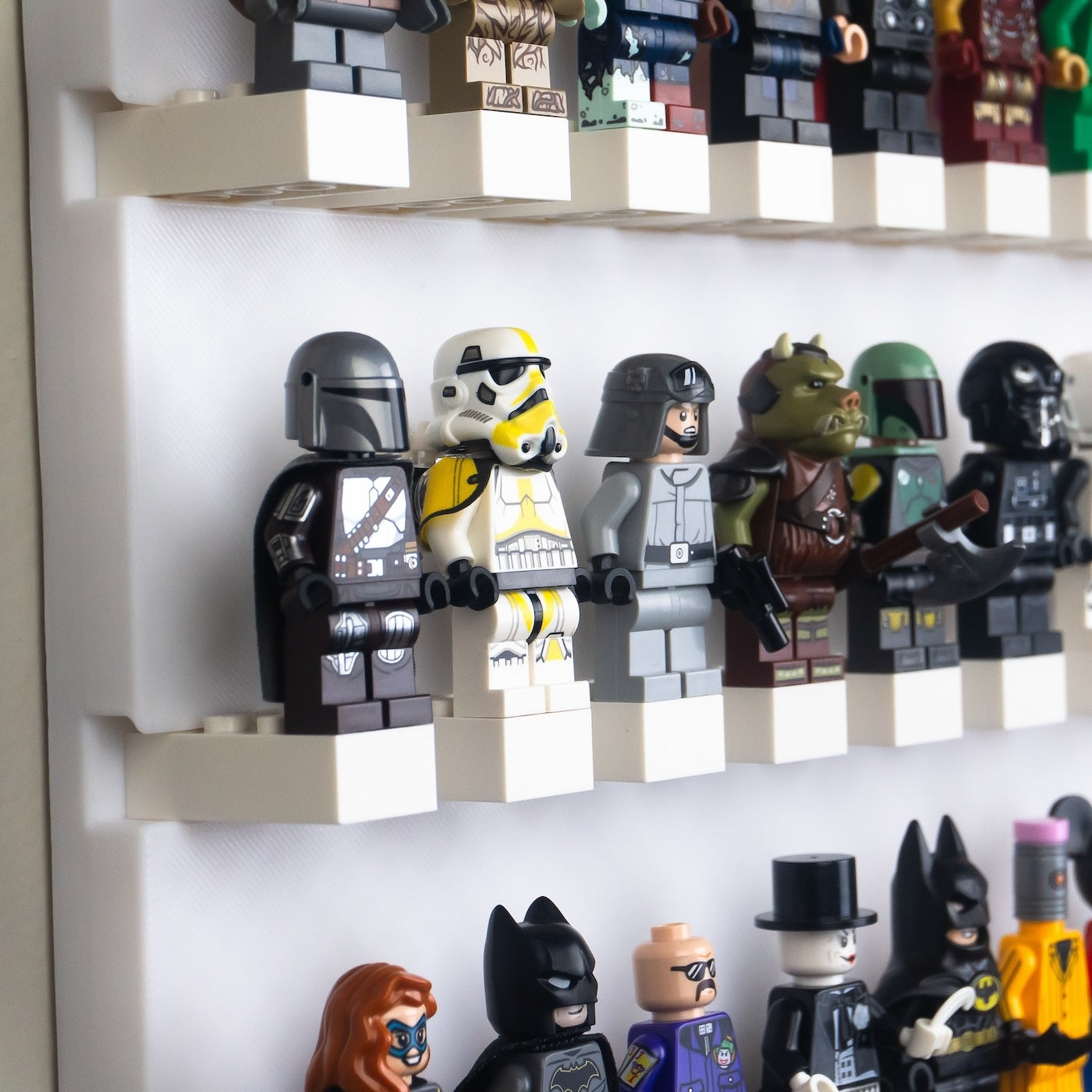  A corner view of a multi-tiered shelf displaying a variety of mini-figures, some with helmets and others representing different species.