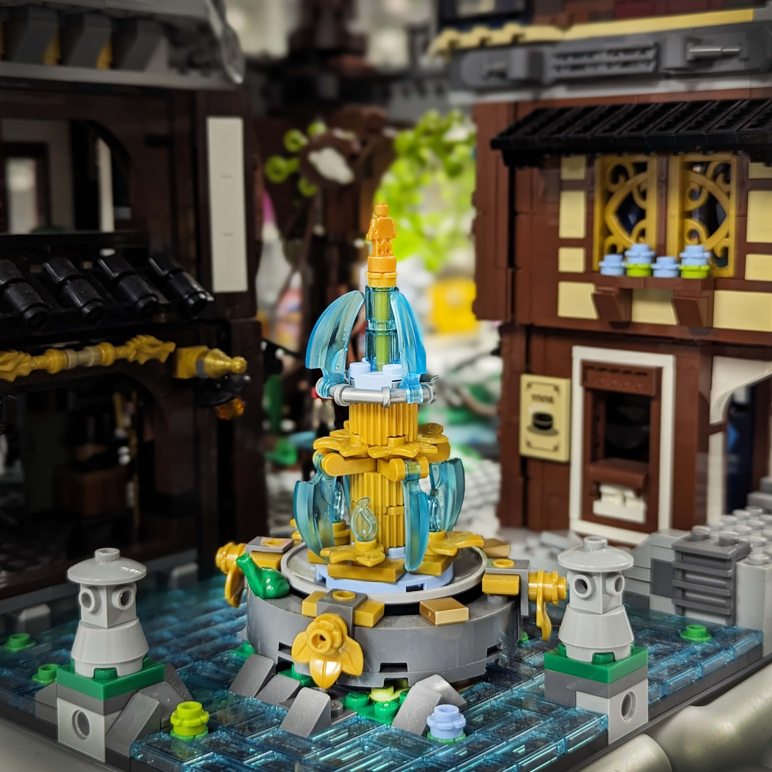 Custom building kit of LEGO of a park fountain with multiple level water falls gold statues and a frog on a grey base set in a swappy/lake setting on a white background