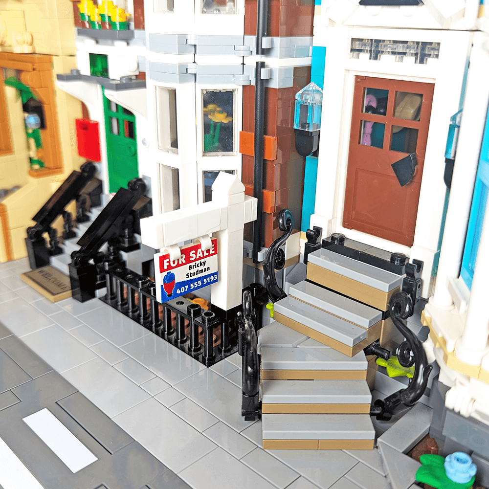 a for sale sign in front of a lego city home
