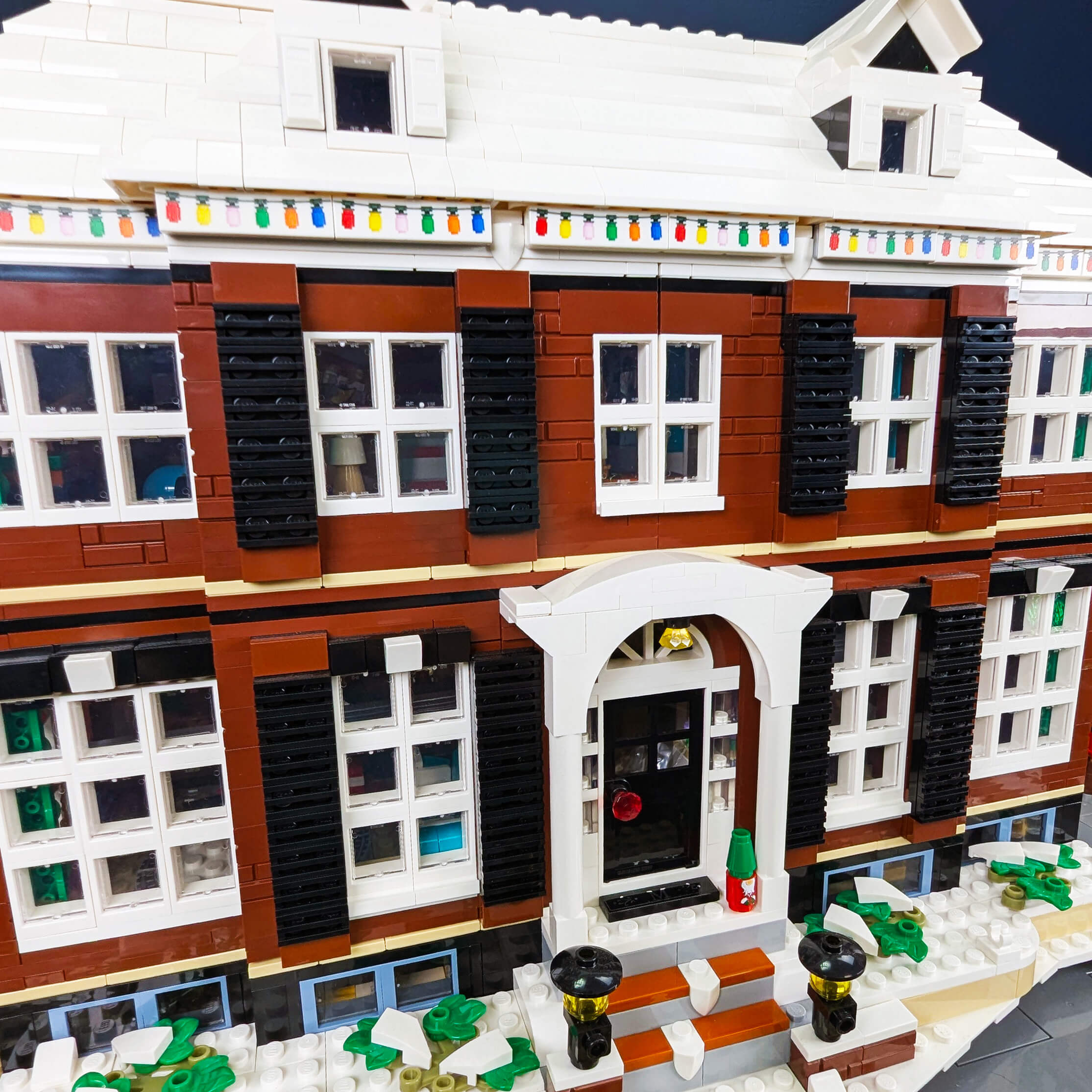 Detailed LEGO model of a two-story house with Christmas lights.