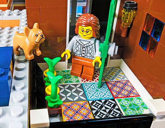 LEGO minifig with a dog enjoying her colorful spanish style floor tiles on a back porch style setting lego moc