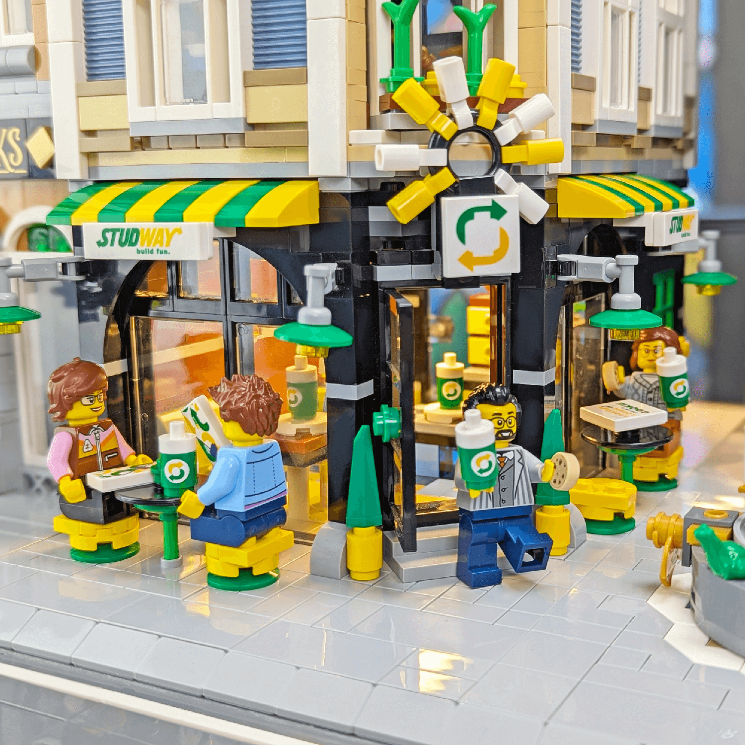 lego minifigures sitting outside of a subway moc store