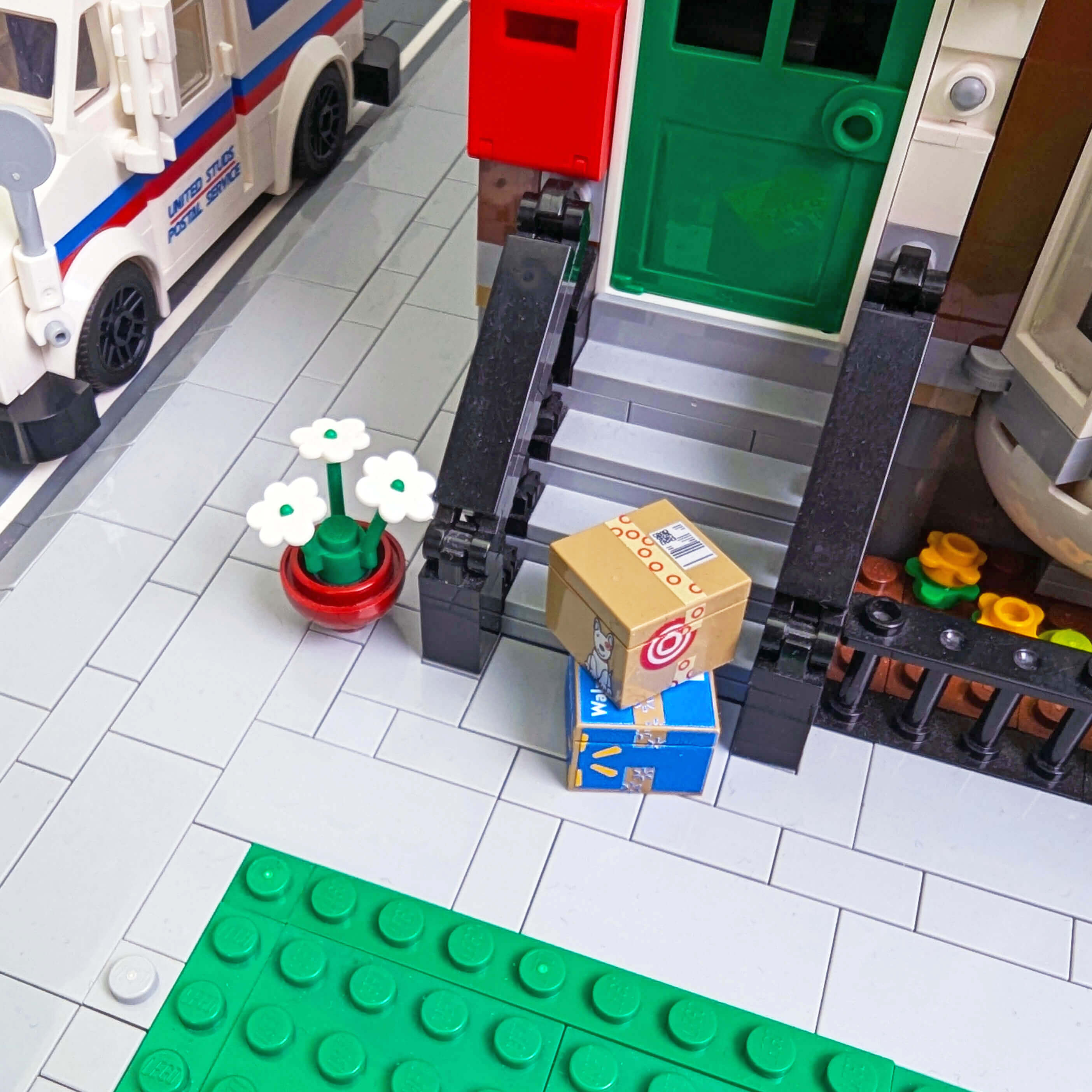 Brick built model of a mailbox with a package and flowers on a tiled floor