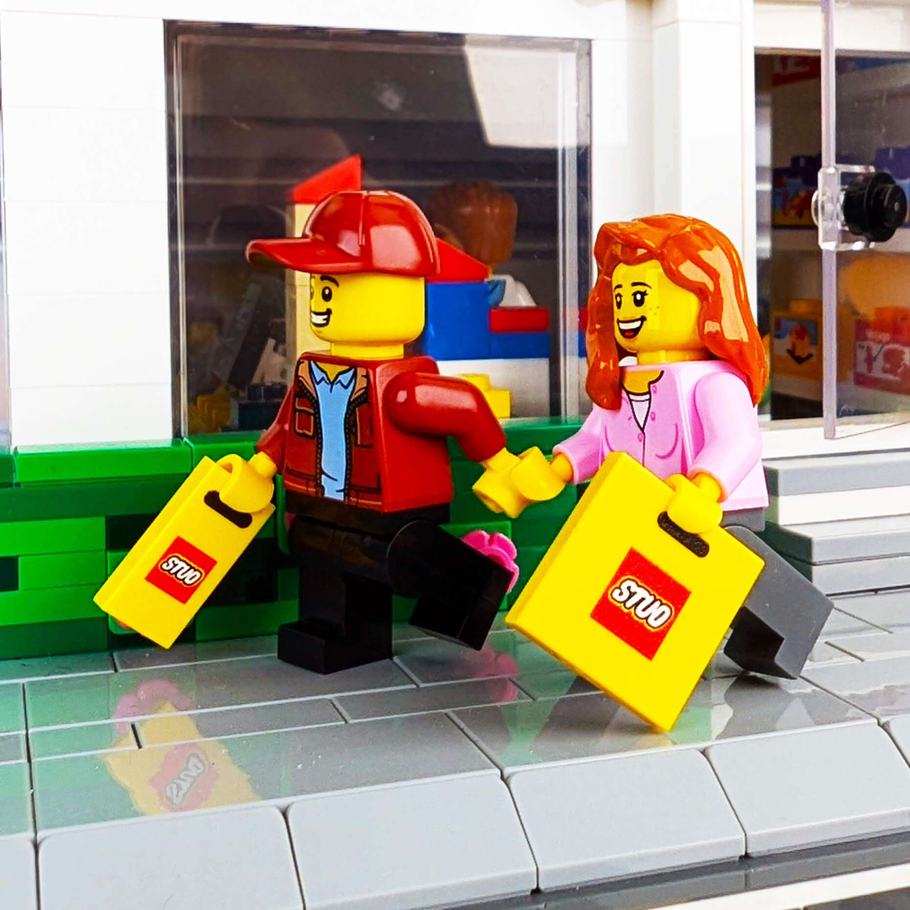 Two minifigs with shopping bags in front of a store window