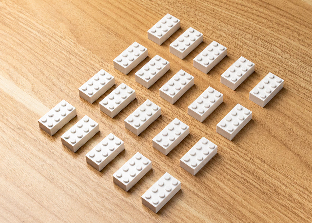 a wide photo of white lego bricks, 2 by 4 size displayed on a table diagonally. 